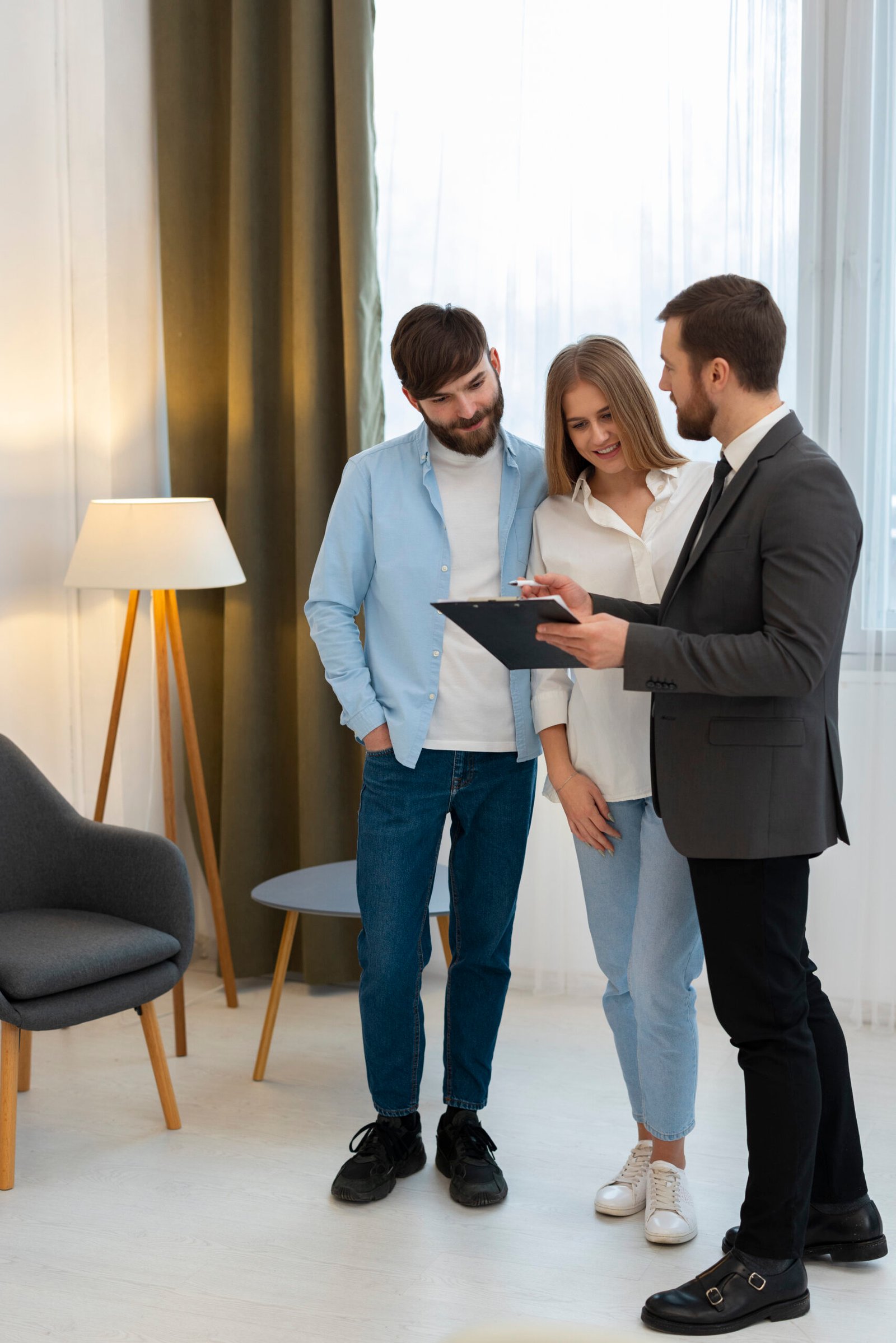 agente-inmobiliario-masculino-haciendo-negocios-y-mostrando-la-casa-una-posible-pareja-compradora